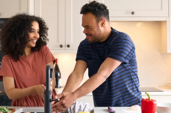 Female NDIS worker working with a young male participants in the kitchen